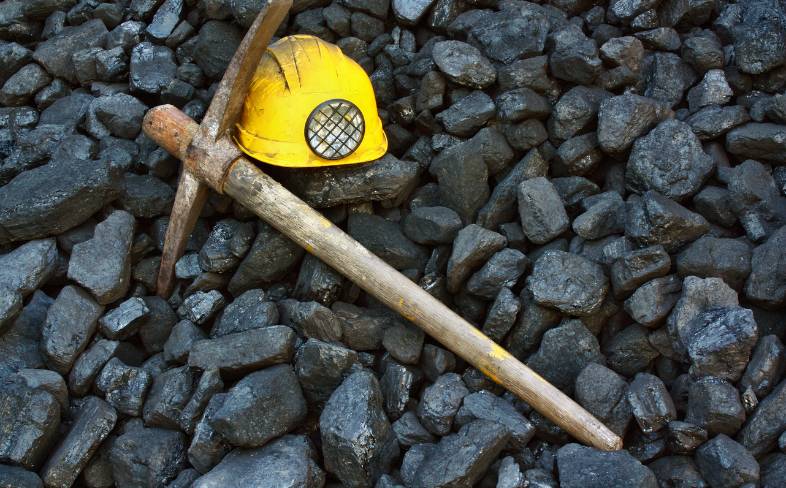 A pickaxe and helmet symbolic of mining industry.
